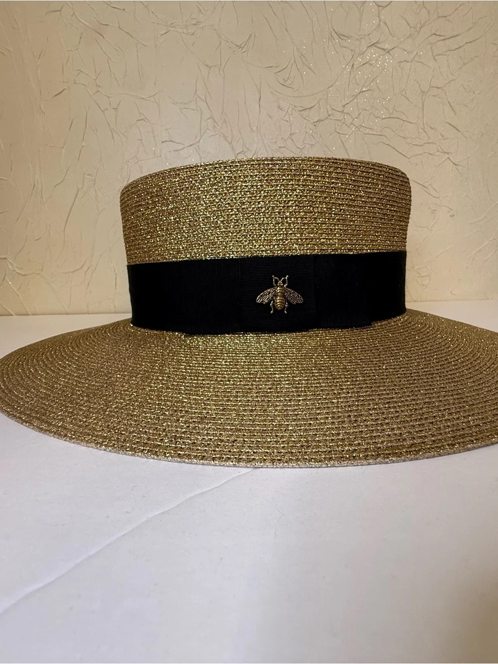 Gucci bee detail hat featuring a gold toned metallic woven design and blk ribbon